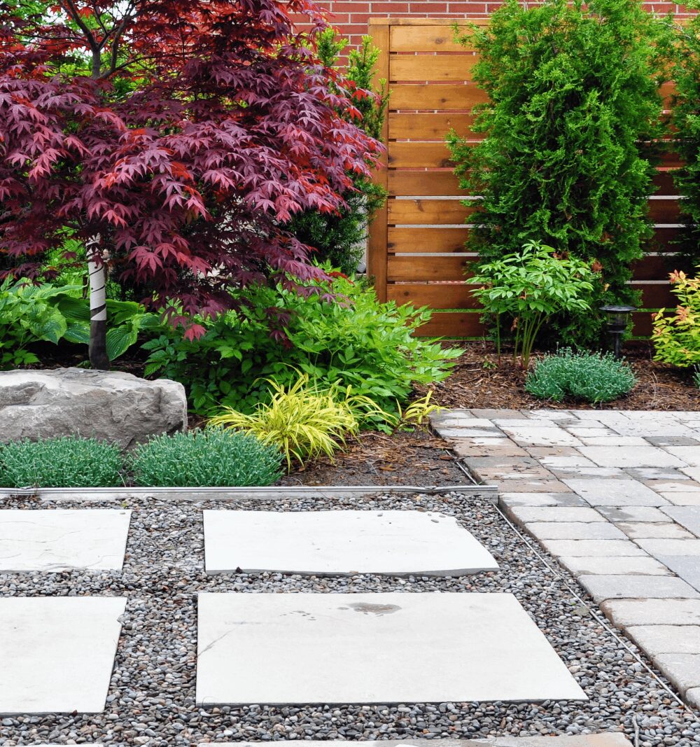 A garden with gravel and stone pavers.