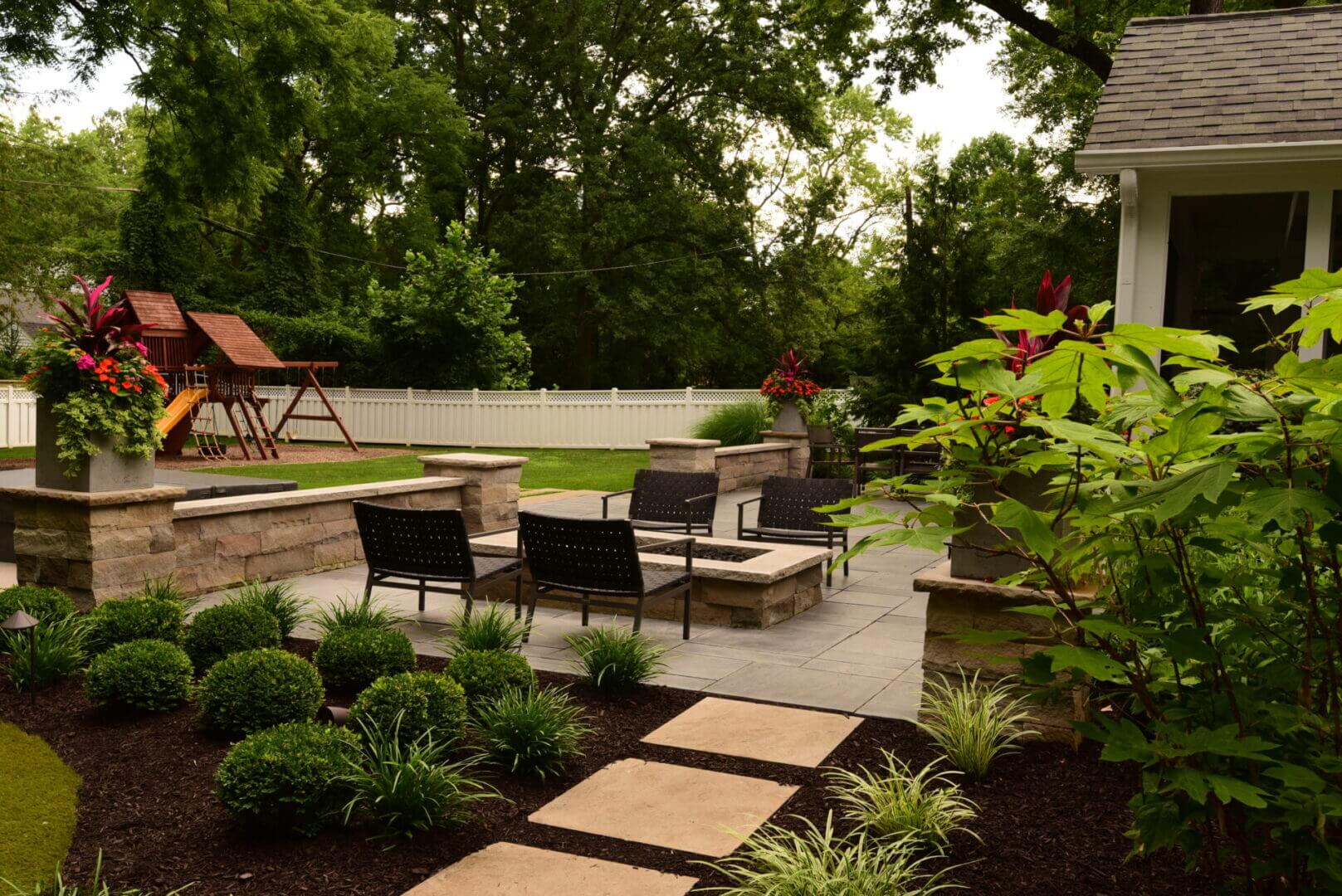 Backyard patio with chairs and playground equipment.