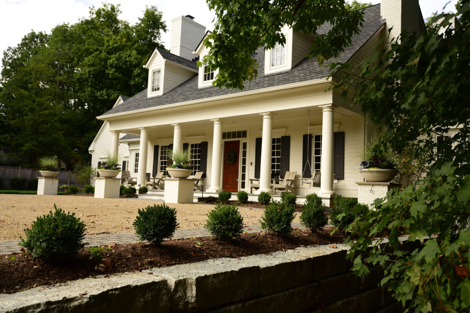 Elegant house with columns and landscaped yard.