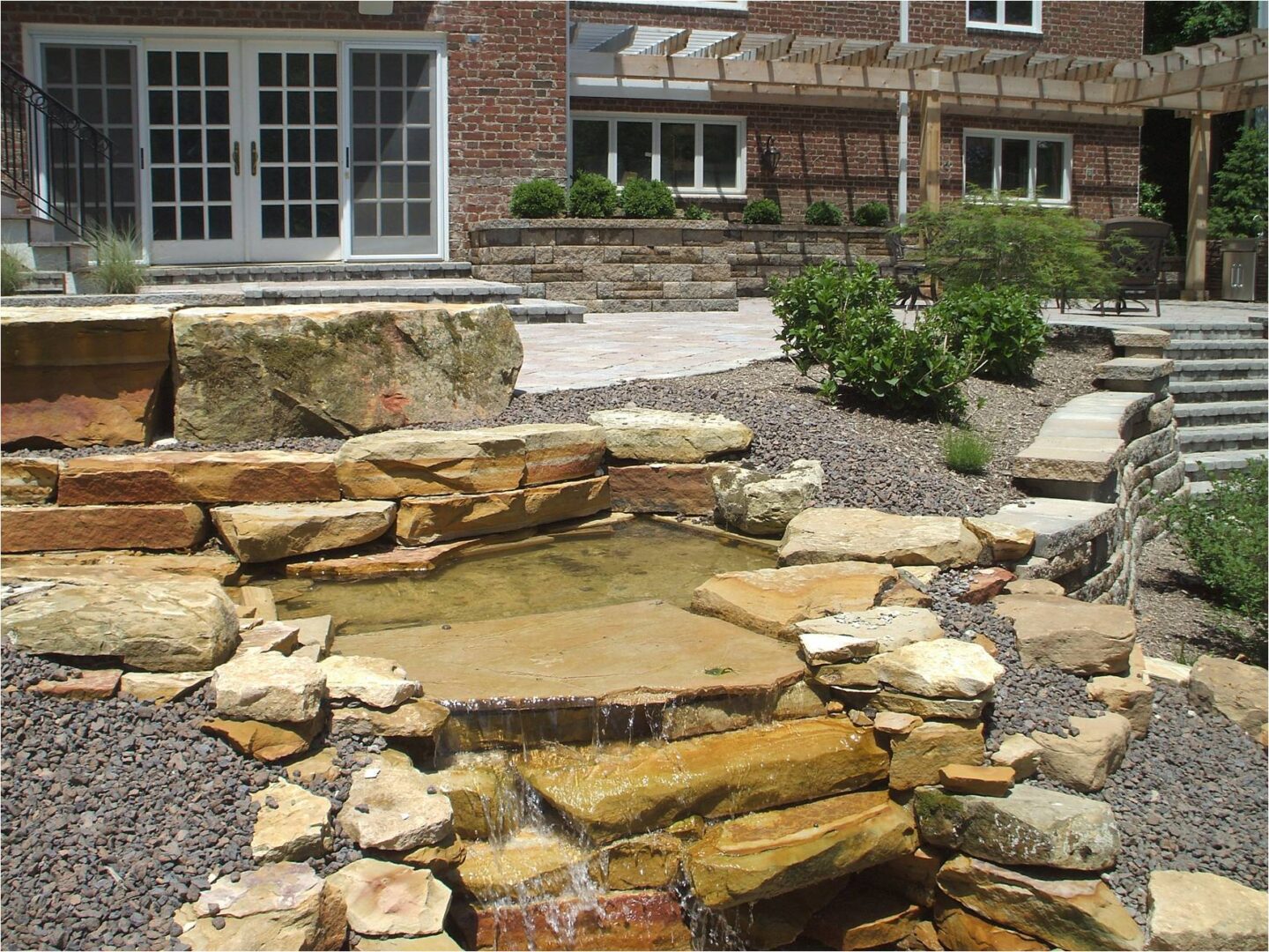 Backyard patio with stone waterfall feature.