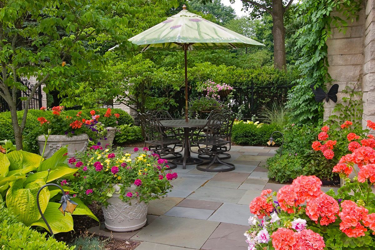 Garden patio with table and flowers.