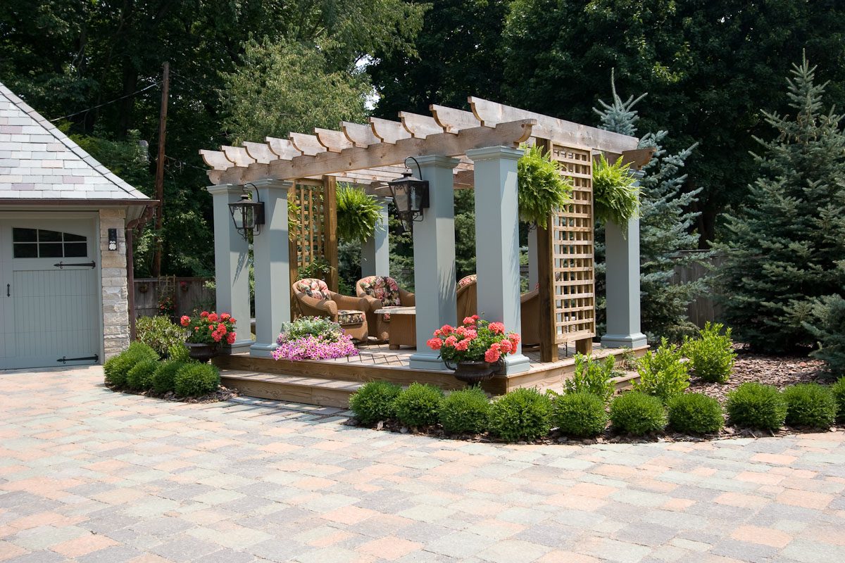 Outdoor pergola with seating and plants.