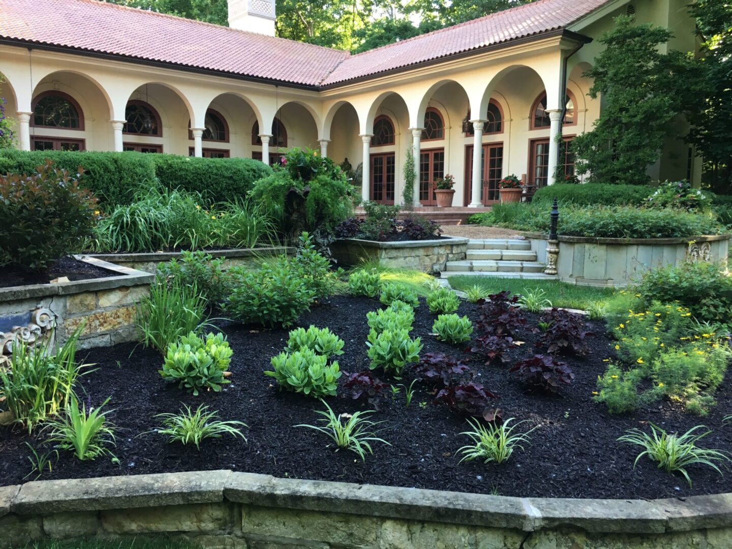 Elegant garden with arched building background.